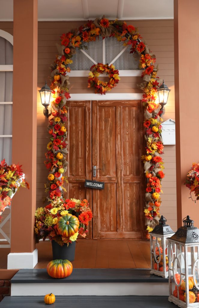 fall decor on front door with a welcome sign and a wreath 